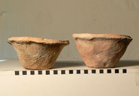 Deux bols à bord biseauté (Beveled Rim Bowls ou BRB), côte à côte. Ces poteries sont faites d'argile brute moulée dans le sol.