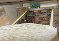 Salage mécanique d'un fromage de Brie. Société Fromagère de la Brie à St-Siméon.